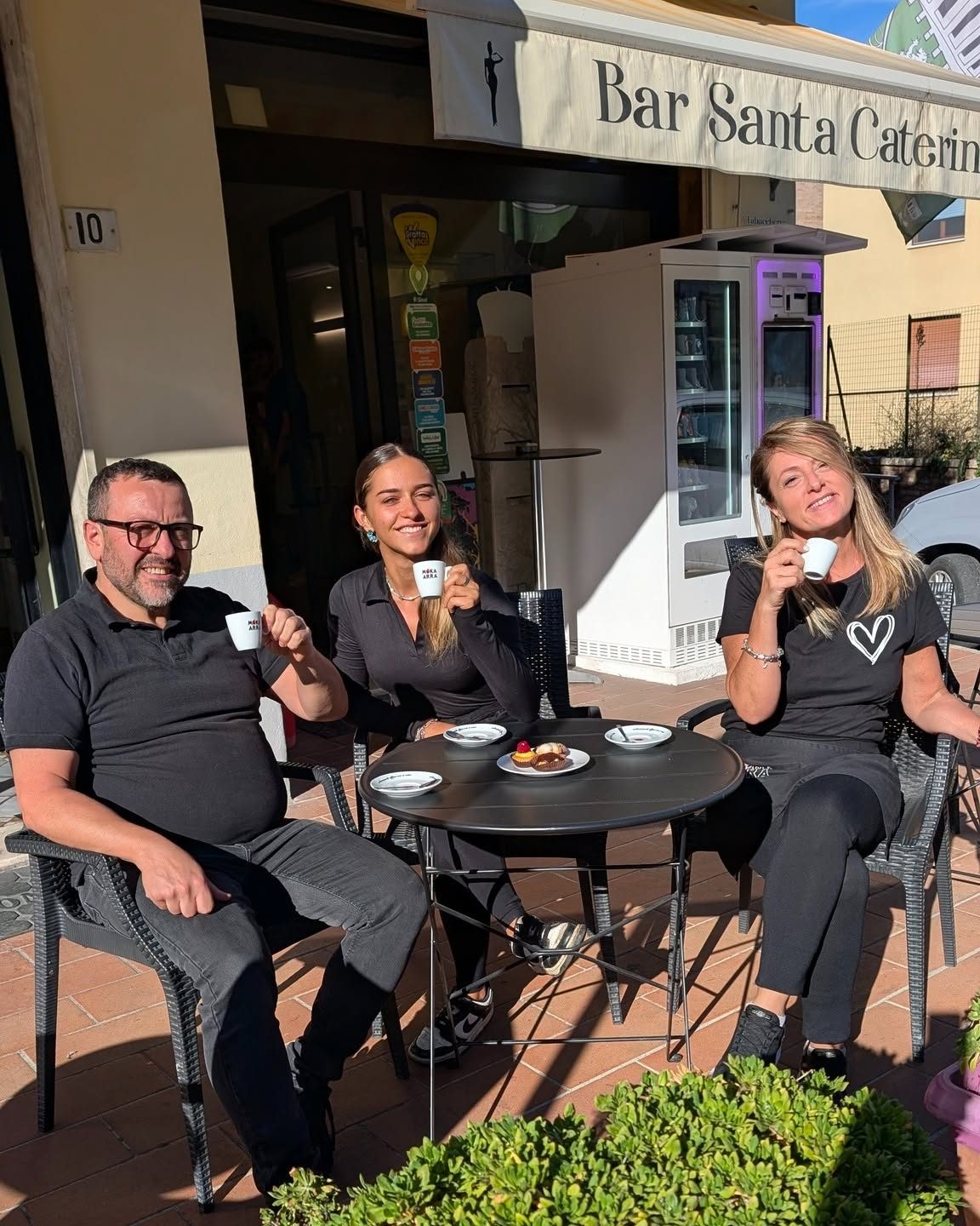 Lo staff davanti al Bar Santa Caterina con caffè e pasticcini