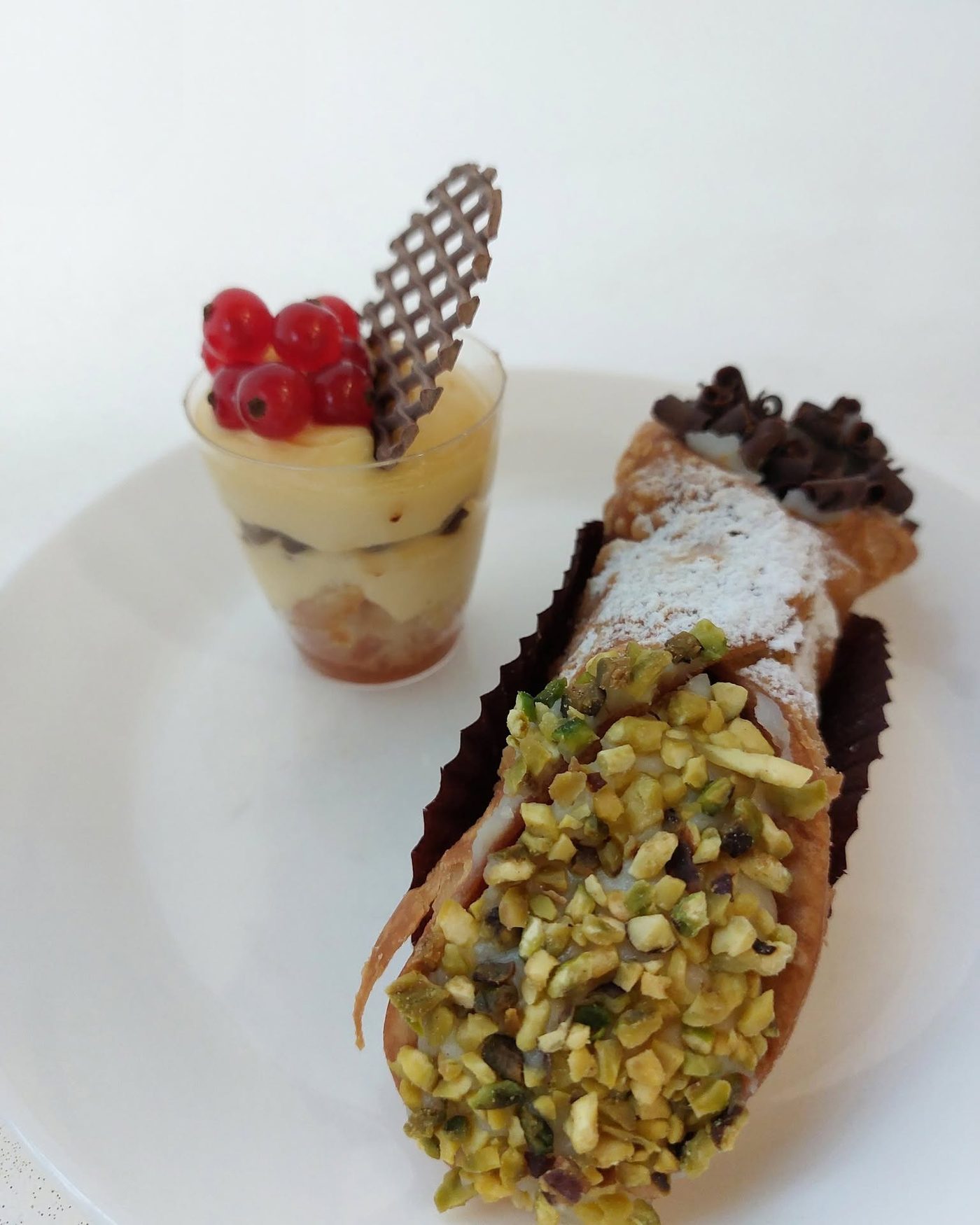 Cannolo siciliano al pistacchio e coppa di crema con ribes