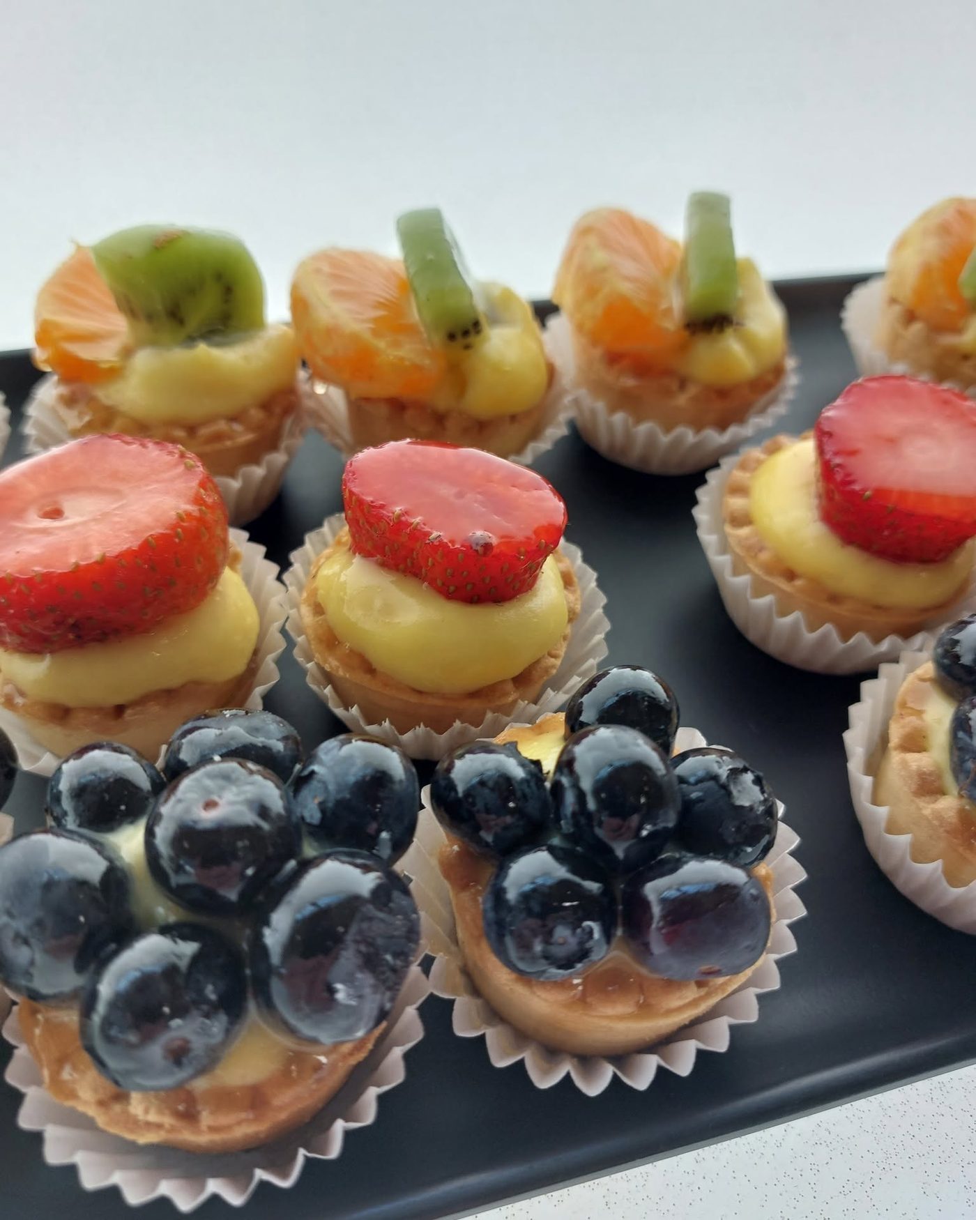 Crostatine mignon con crema e frutta fresca: fragole, mirtilli, kiwi e mandarino